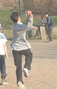 Young people playing cricket.