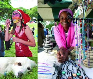 Girl with face painting blows bubbles, stall holder, and a dog lays in the grass.